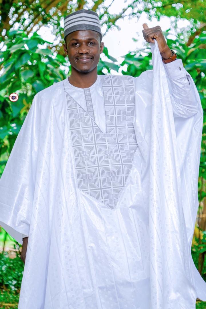 Grand boubou en bazin blanc à plastron brodé, porté en extérieur